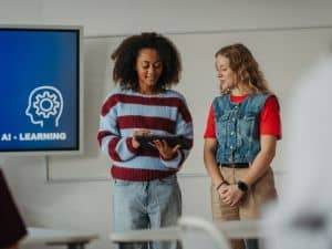Two students reviewing content on a tablet during an AI learning lesson in a classroom setting