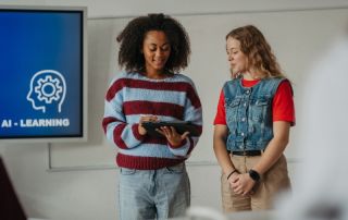 Two students reviewing content on a tablet during an AI learning lesson in a classroom setting